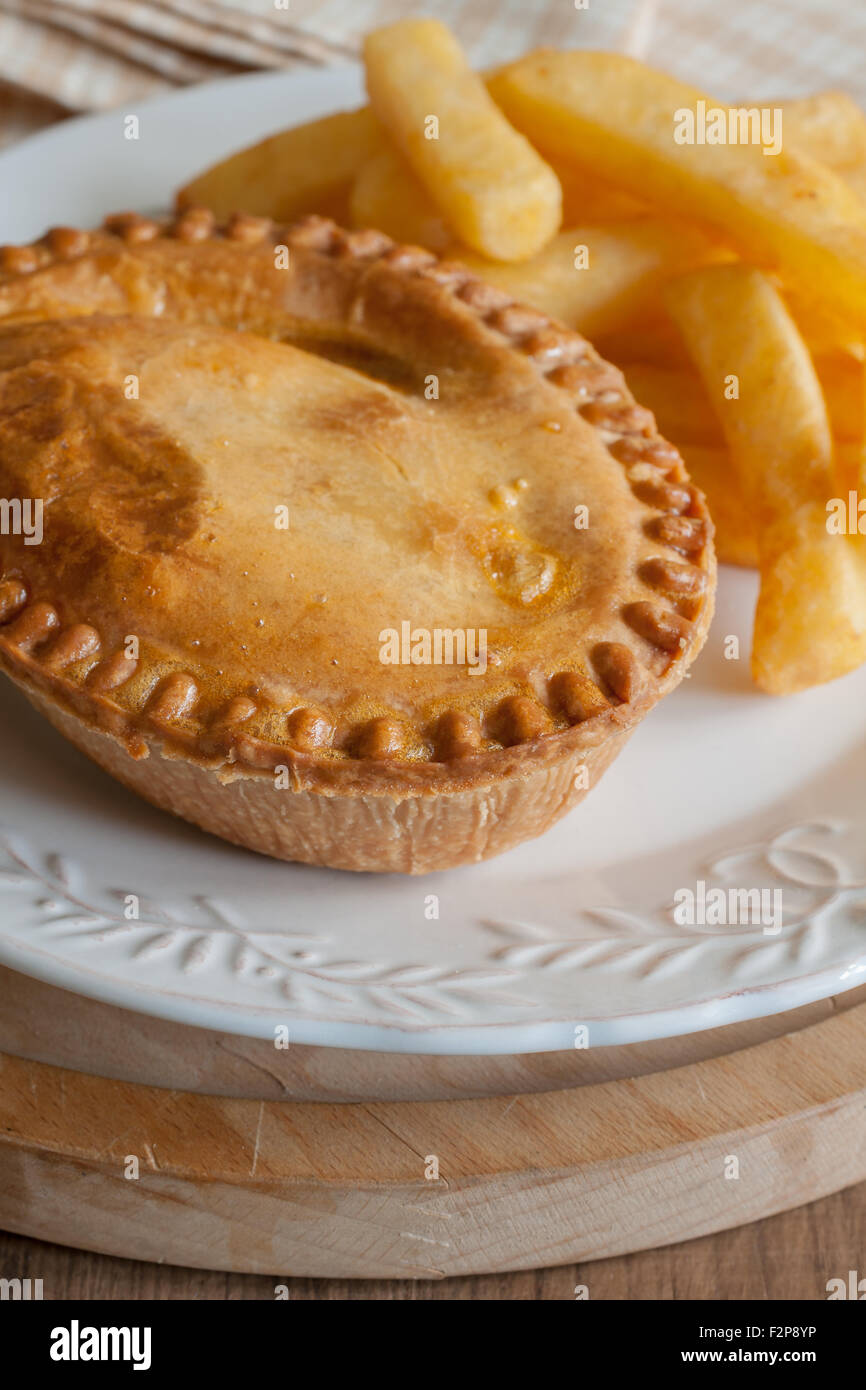 Savoury meat pie with chips or French fries Stock Photo Alamy