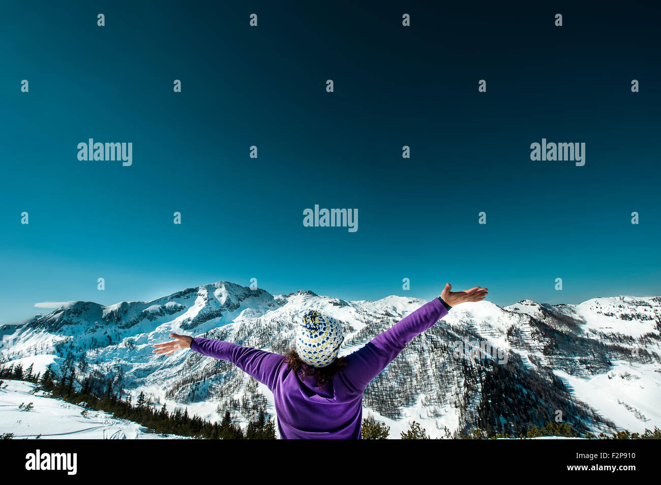 Austria, Altenmarkt-Zauchensee, woman with outstretched arms in mountainscape Stock Photo