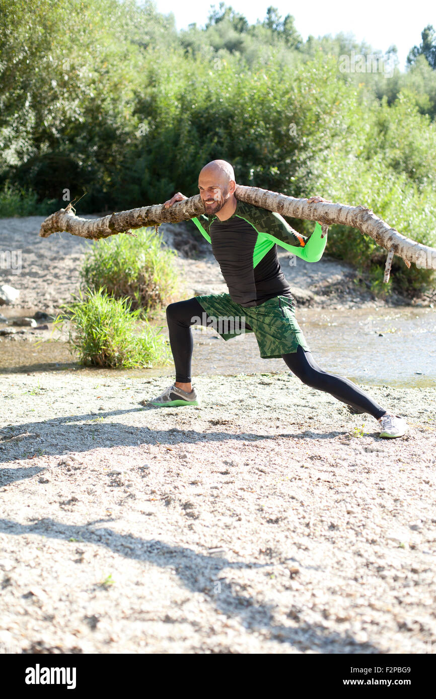 Man doing CrossFit exercise with tree trunk on his shoulders Stock ...