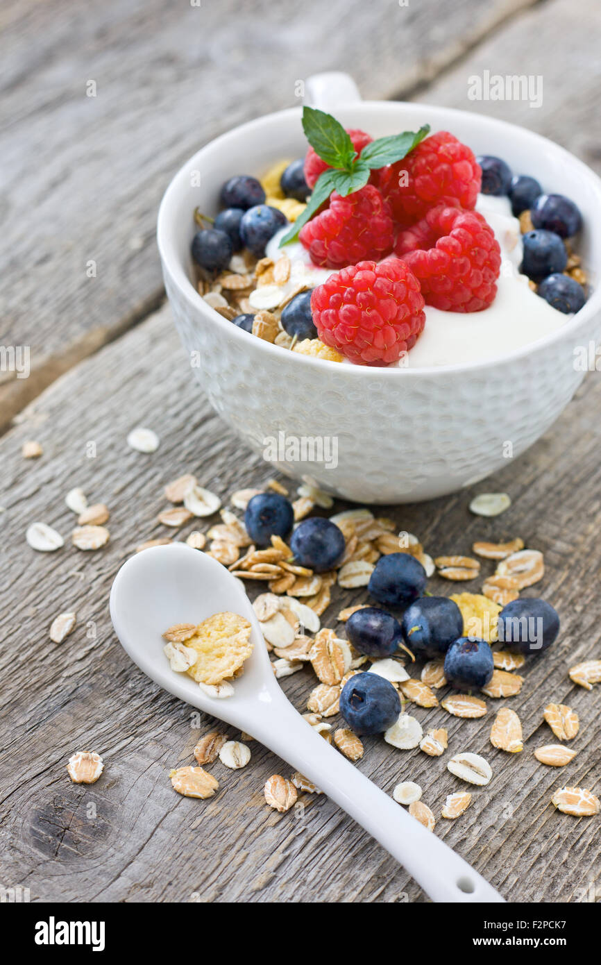 muesli with fresh berries: blueberries, raspberries and yogurt on a wooden background Stock Photo