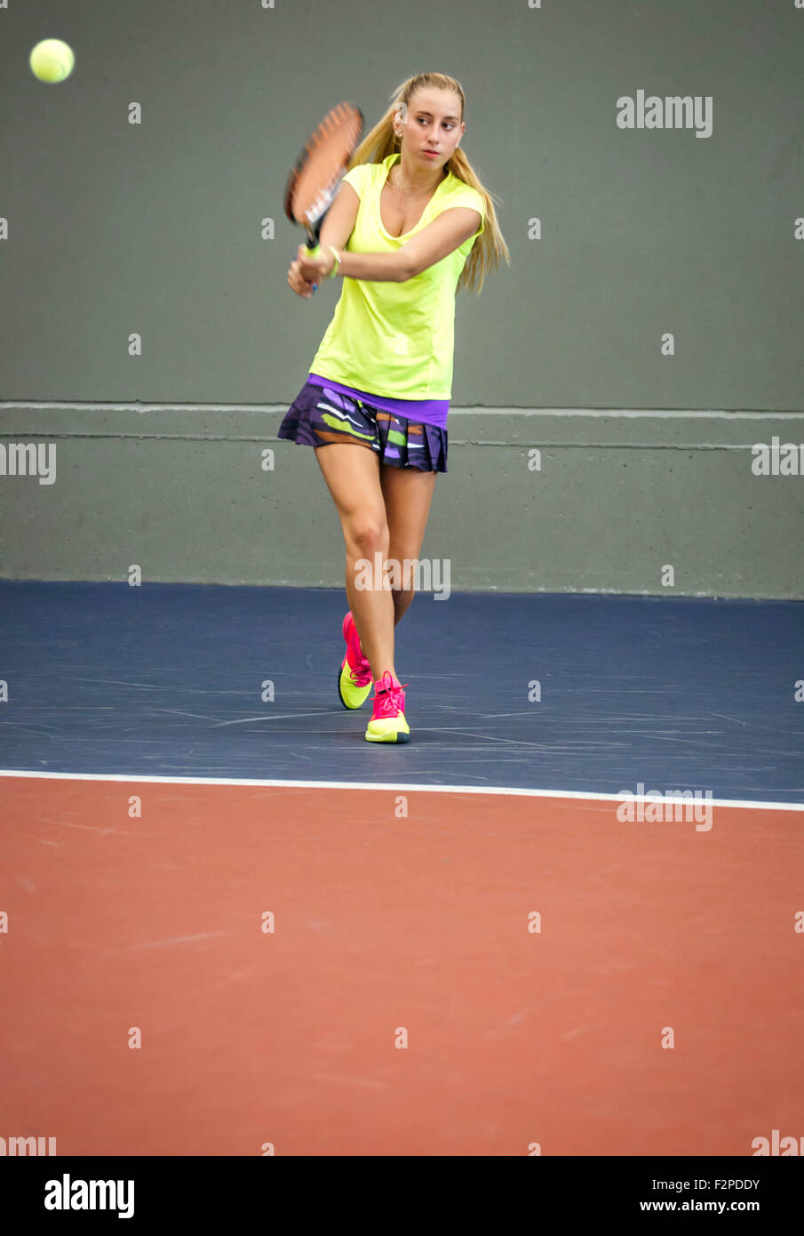 Young woman playing tennis in an indoor tennis center Stock Photo