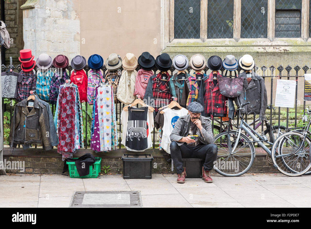 Clothing street trader looking at mobile phone Cambridge Cambridgeshire England Stock Photo