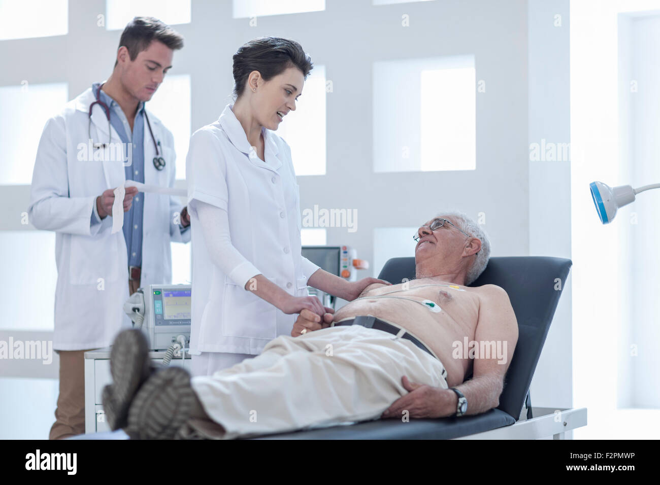 Senior man doing check up in hospital, nurse calming him Stock Photo