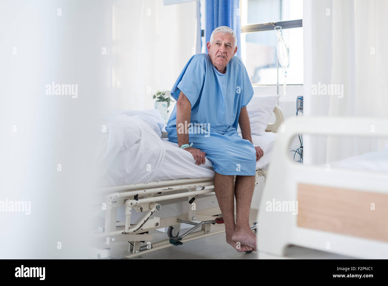 Senior patient sitting on hospital bed Stock Photo