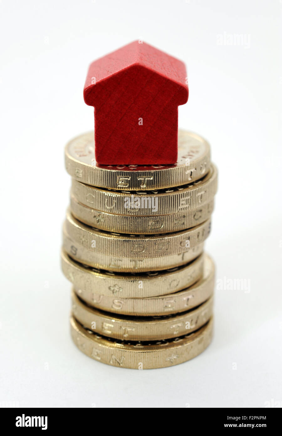 MONOPOLY HOUSE ON STACK OF ONE POUND COINS RE HOUSE PRICES VALUES PROPERTY MARKET HOME BUYING MORTGAGES SALES BUYERS RISING UK Stock Photo