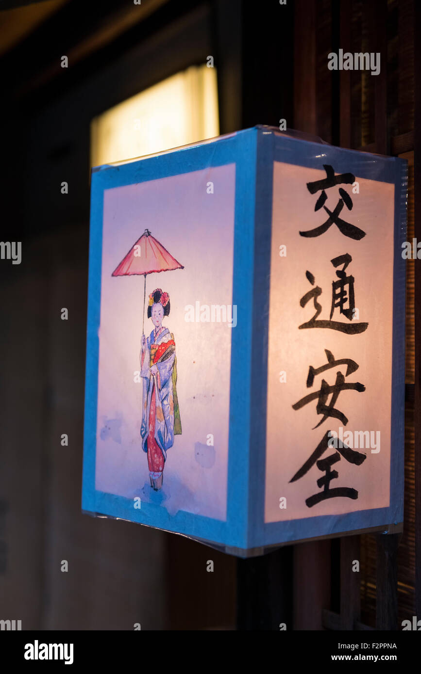 A Japanese hand decorated paper lantern with a Japanese lady or Geisha on it in the doorway of a building in Gion in Kyoto Stock Photo