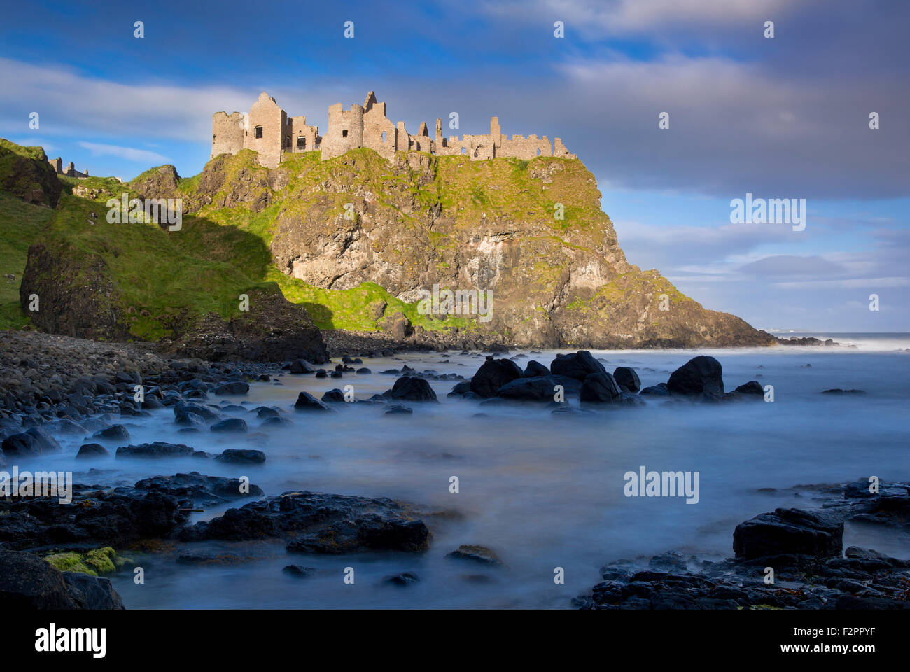 Sunrise over Dunluce Castle along northern coast of County Antrim, Northern Ireland, UK Stock Photo