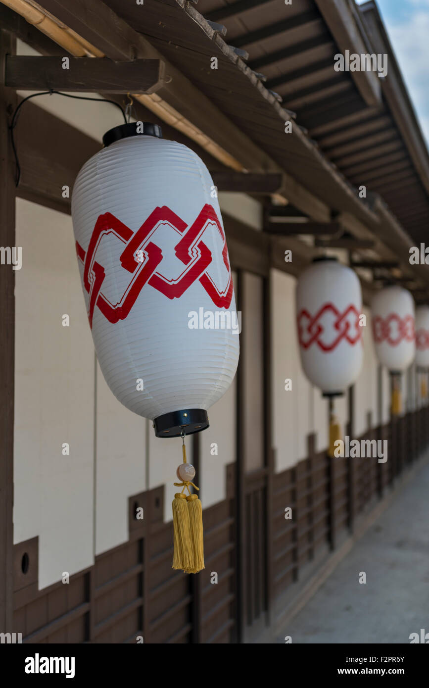 Line of Japanese paper lanterns hanging from a building Stock Photo