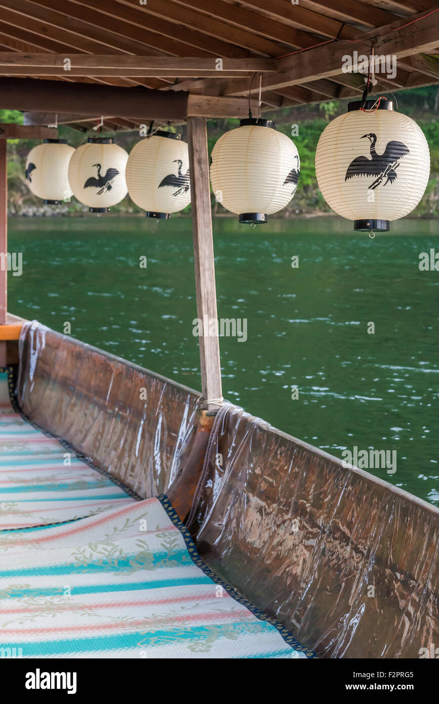 Paper lanterns with a cormorant logo on them hanging from the roof of a tourist boat Stock Photo