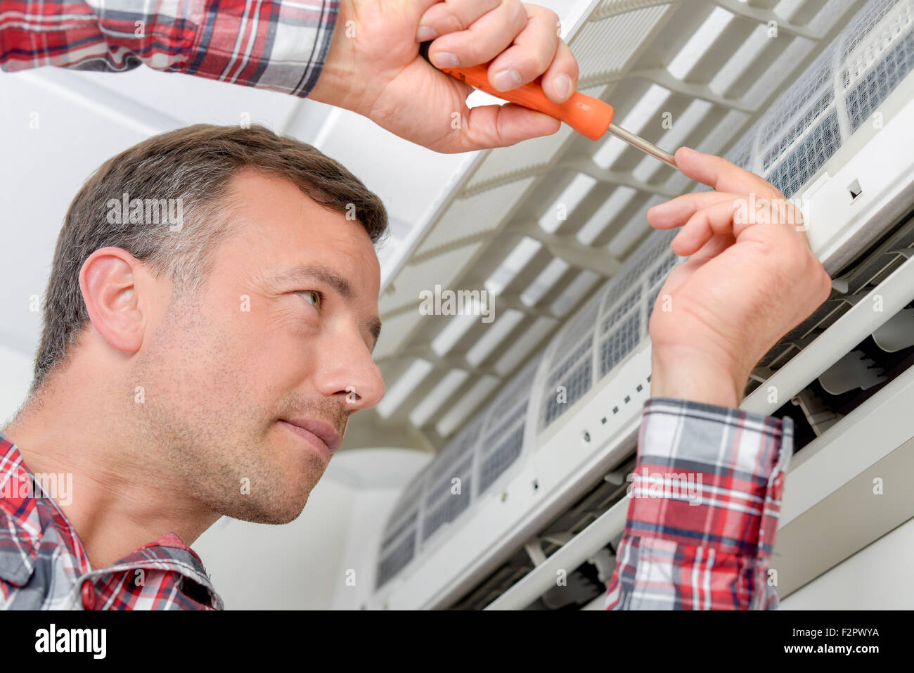 Electrician fitting an air conditioning unit Stock Photo Alamy