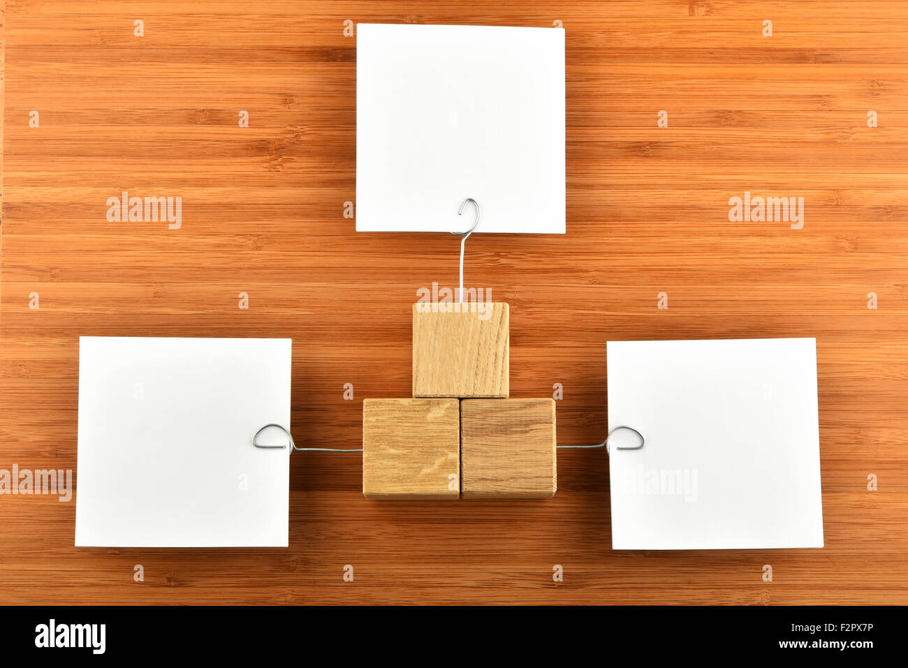 Different Opinions - Three white paper notes with wooden holders in different directions on bamboo wooden background for present Stock Photo