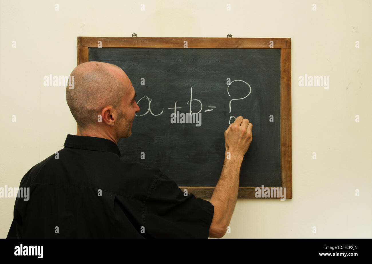 teacher writing with chalk on blackboard Stock Photo