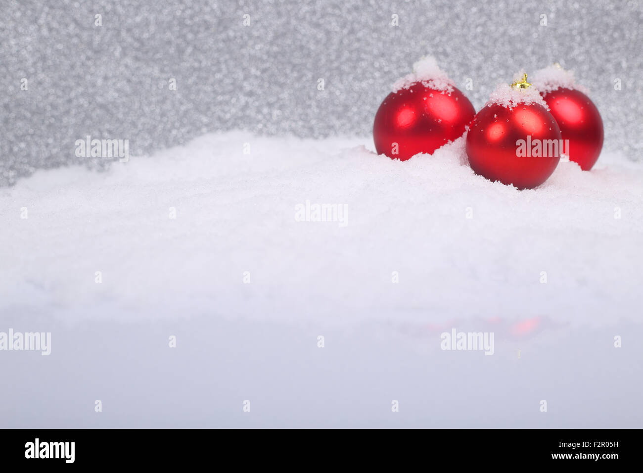 Christmas decorative red balls on snow on glitter background Stock Photo Alamy