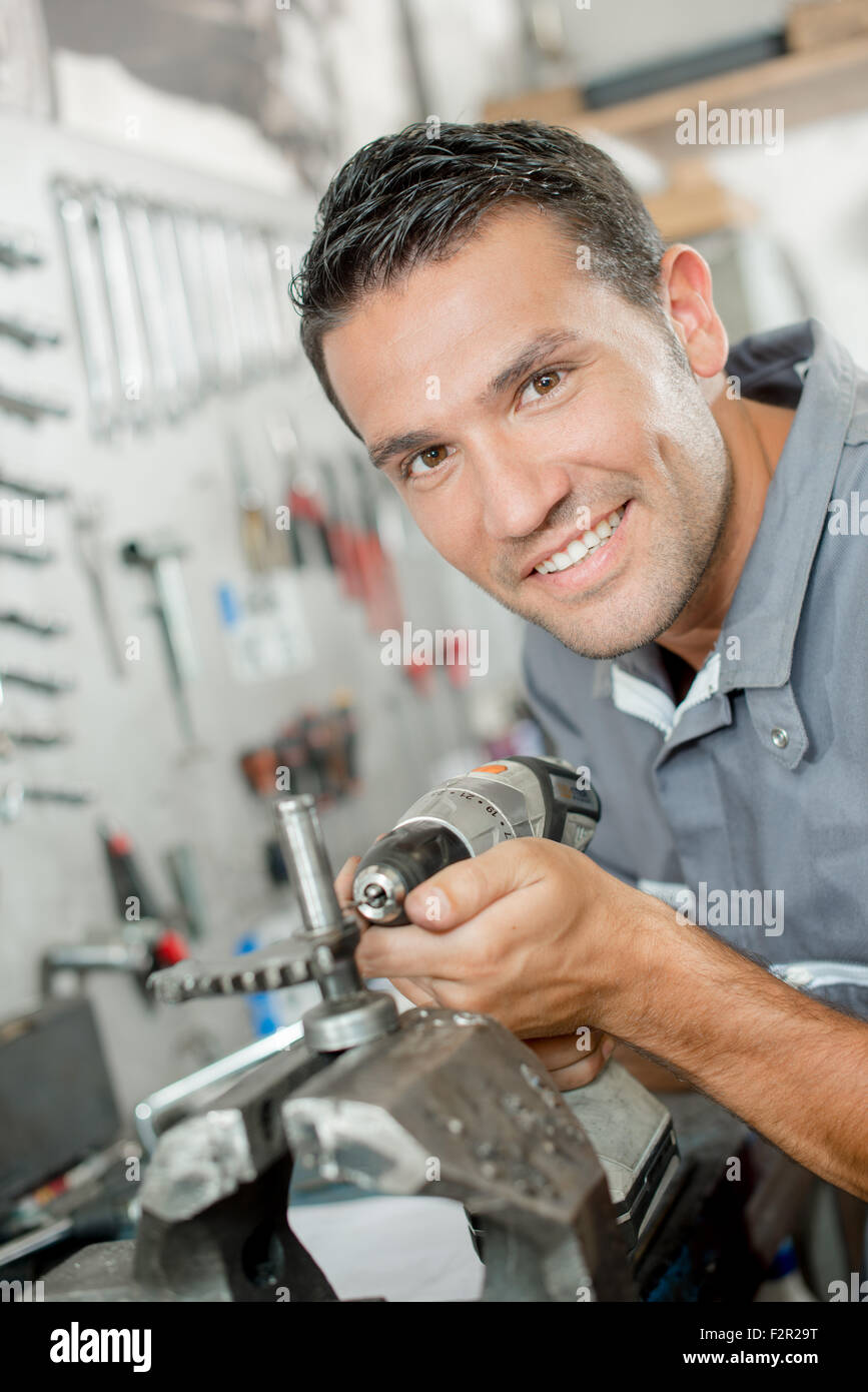 Mechanic using a drill to adjust part Stock Photo Alamy