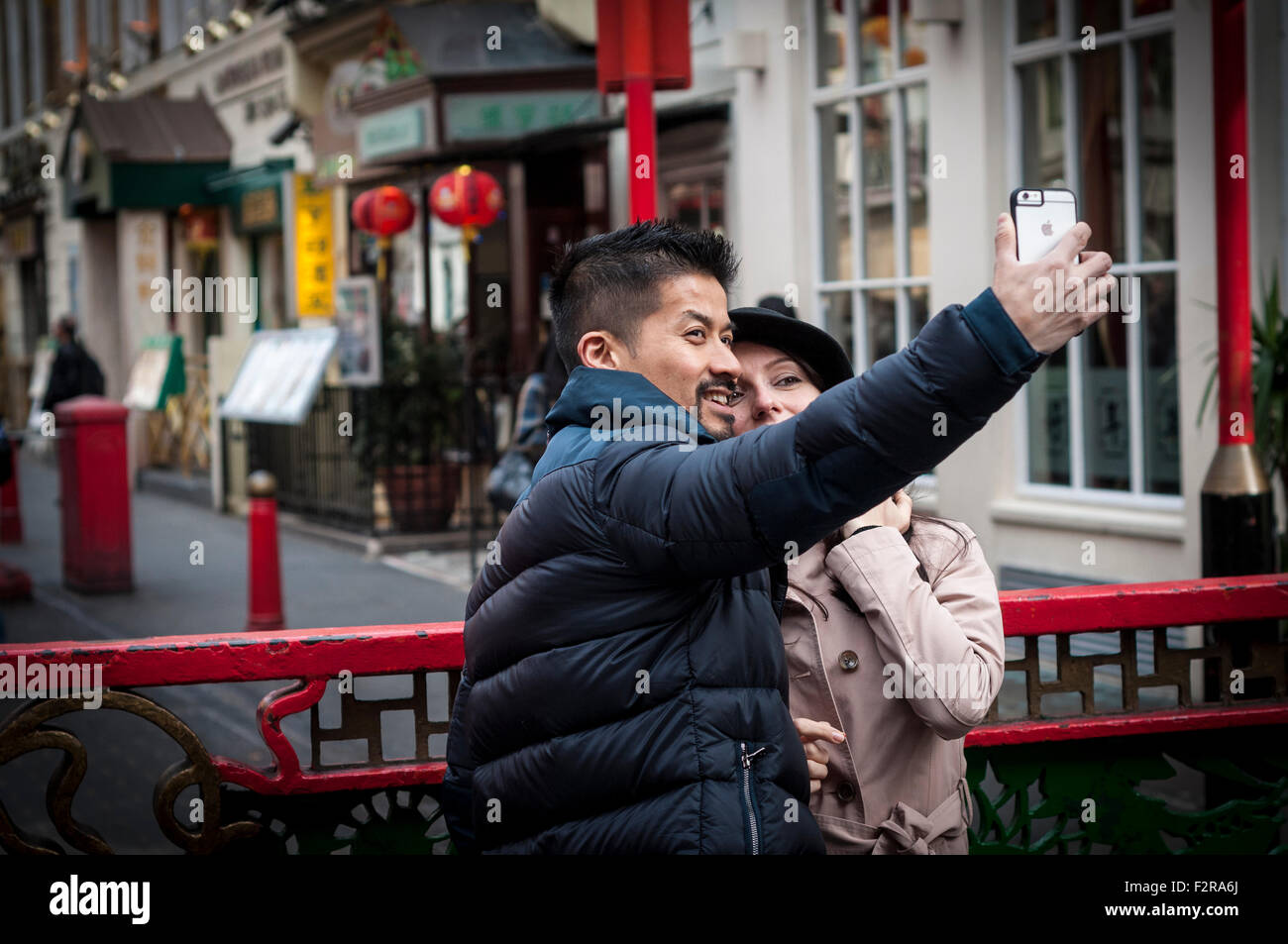 A couple taking selfie with a mobile phone, Chinatown, London, UK Stock Photo