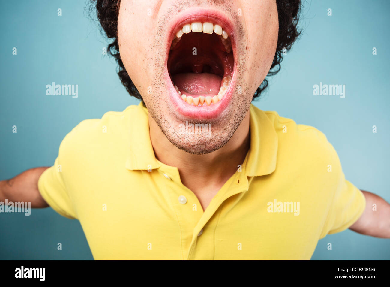 Young man is screaming with his mouth wide open Stock Photo