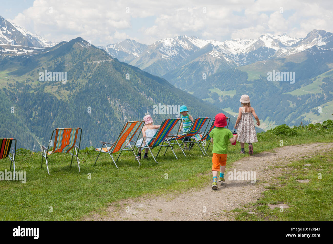Little hikers having a break in deck chairs with a view over Tyrolean Alps Stock Photo
