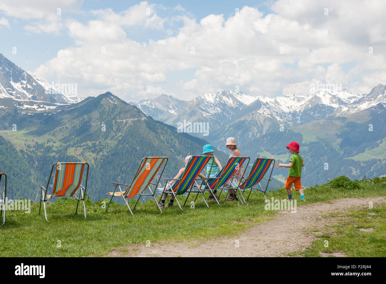Little hikers having a break in deck chairs with a view over Tyrolean Alps Stock Photo