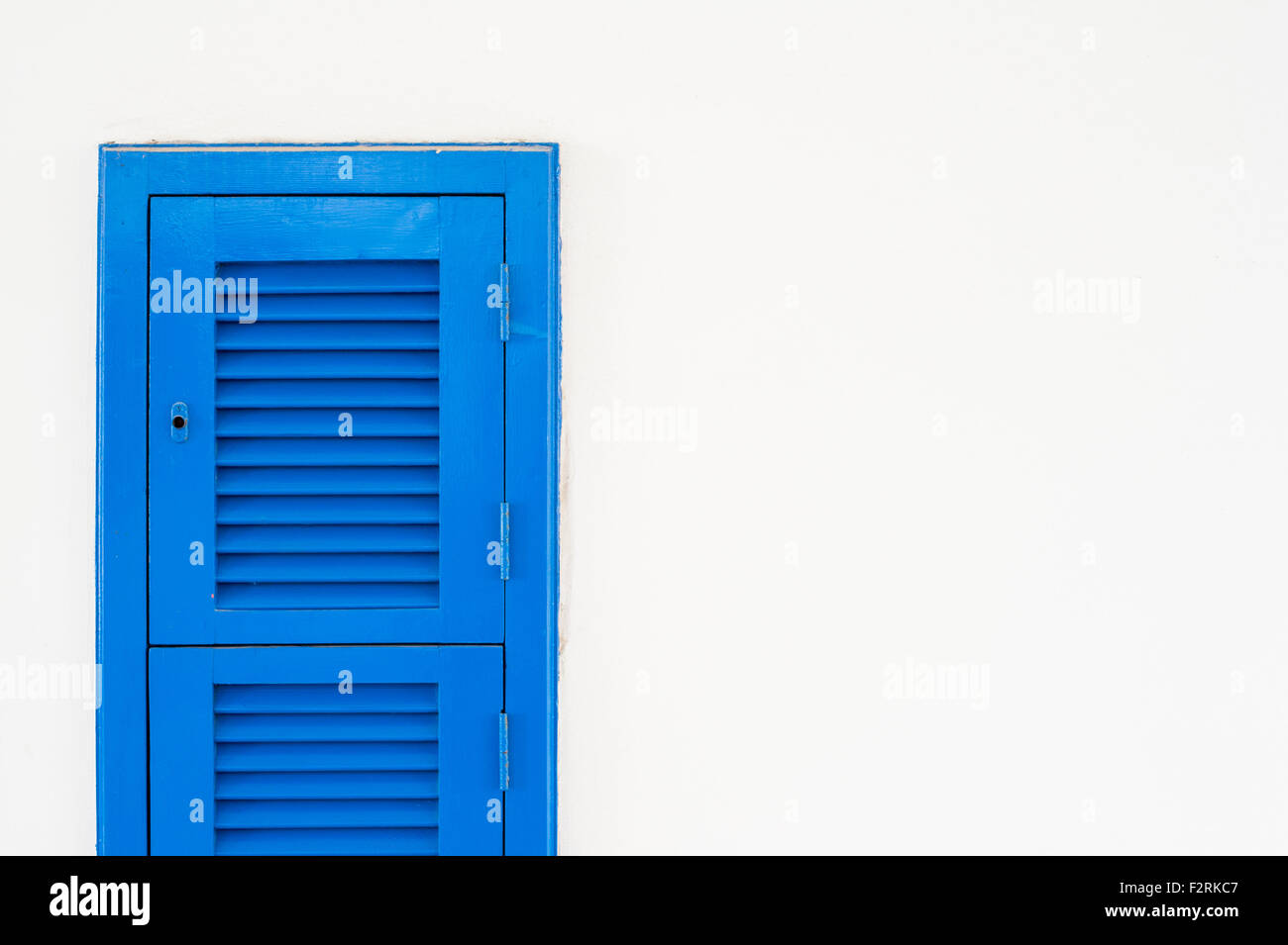 Vertical blue shatter window on white wall with copy space on the right Stock Photo