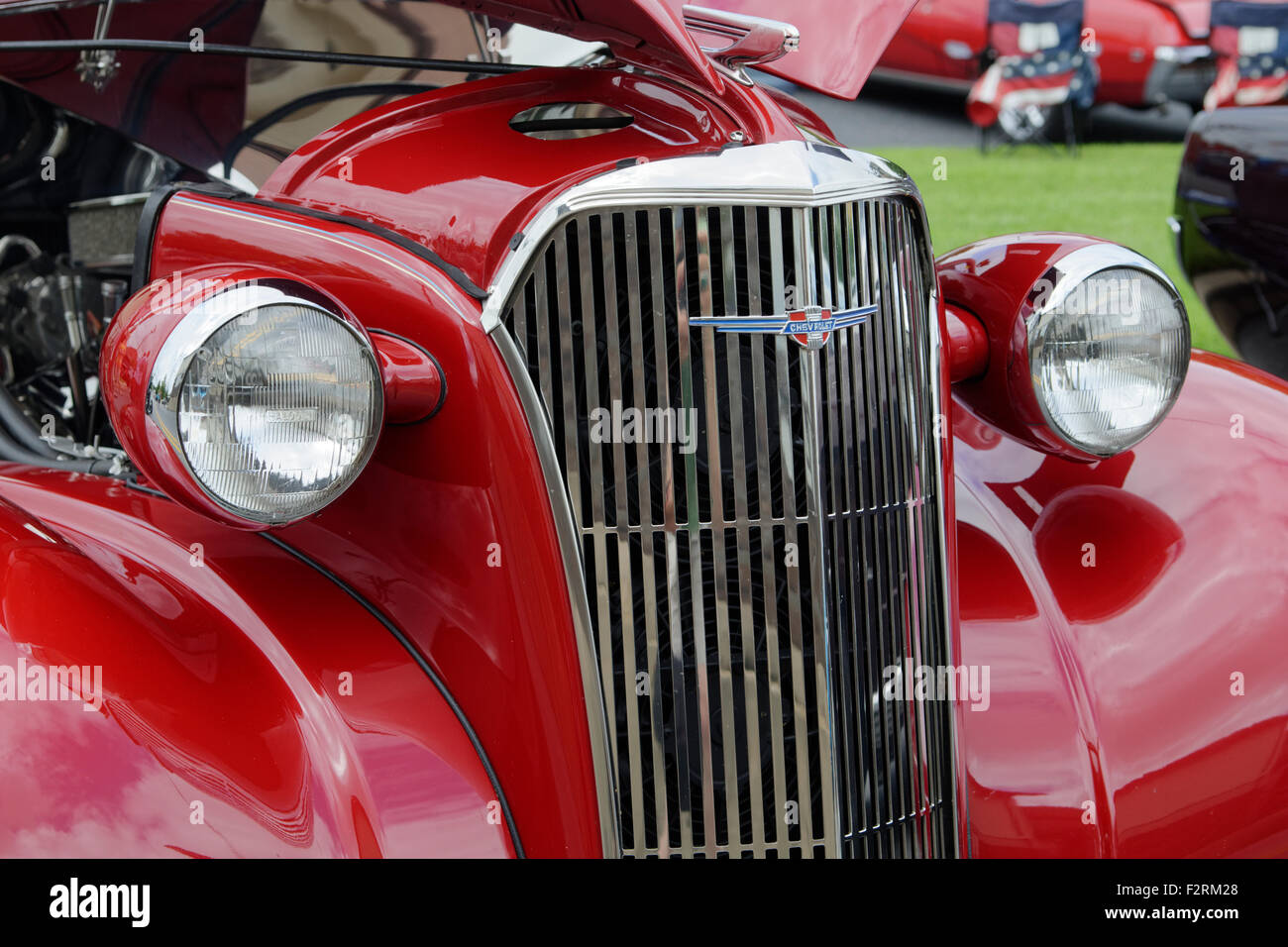 Red Chrysler automobile with hood panels raised, seen at an antique car show. Stock Photo