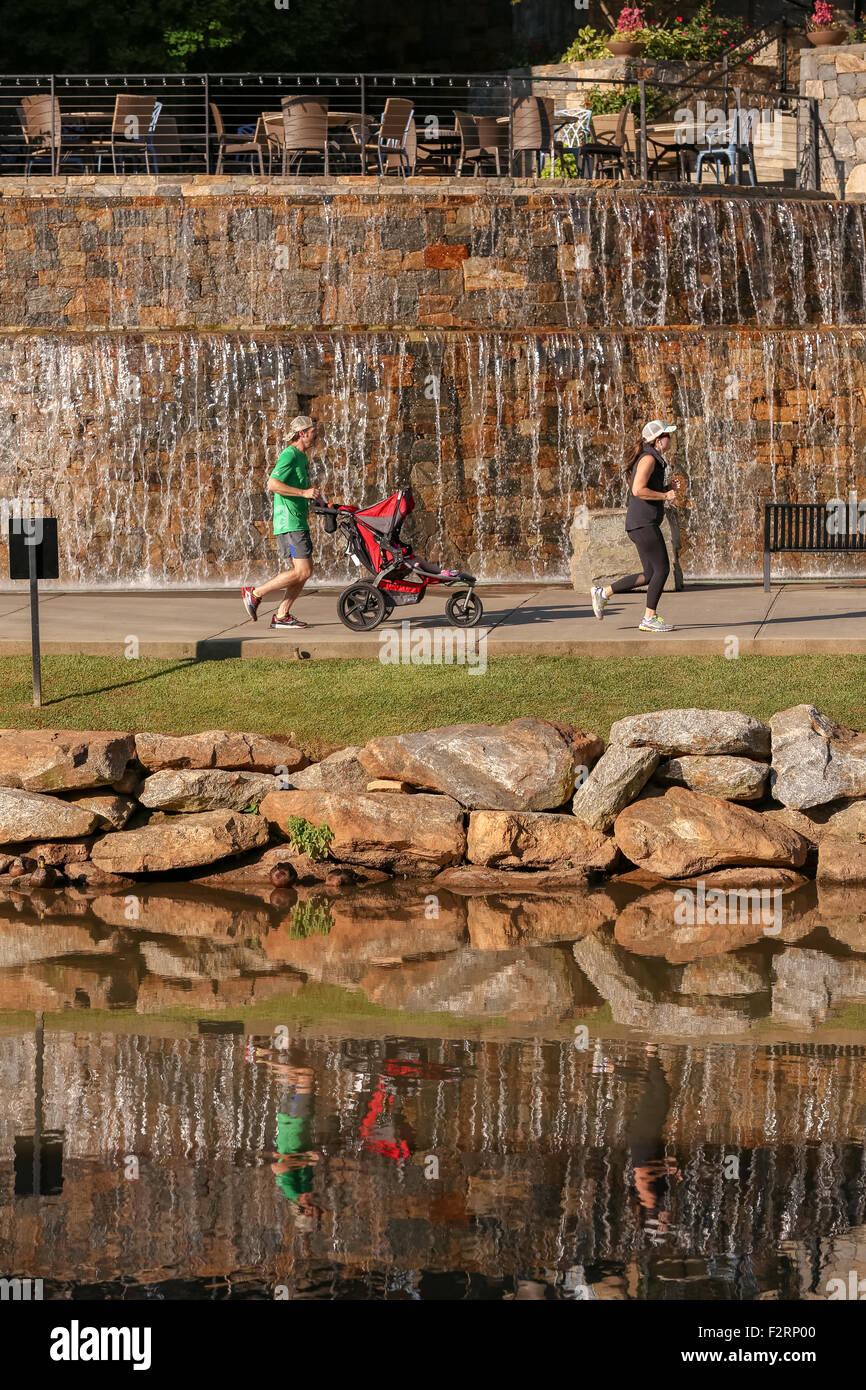 Runners at the Art Crossing and River Place development on the Reedy River in downtown Greenville, South Carolina. Stock Photo