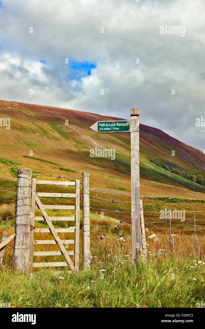 Countryside sign and gate. The sign is showing the path from Glen Lyon at Innerwick to Loch Rannoch Stock Photo