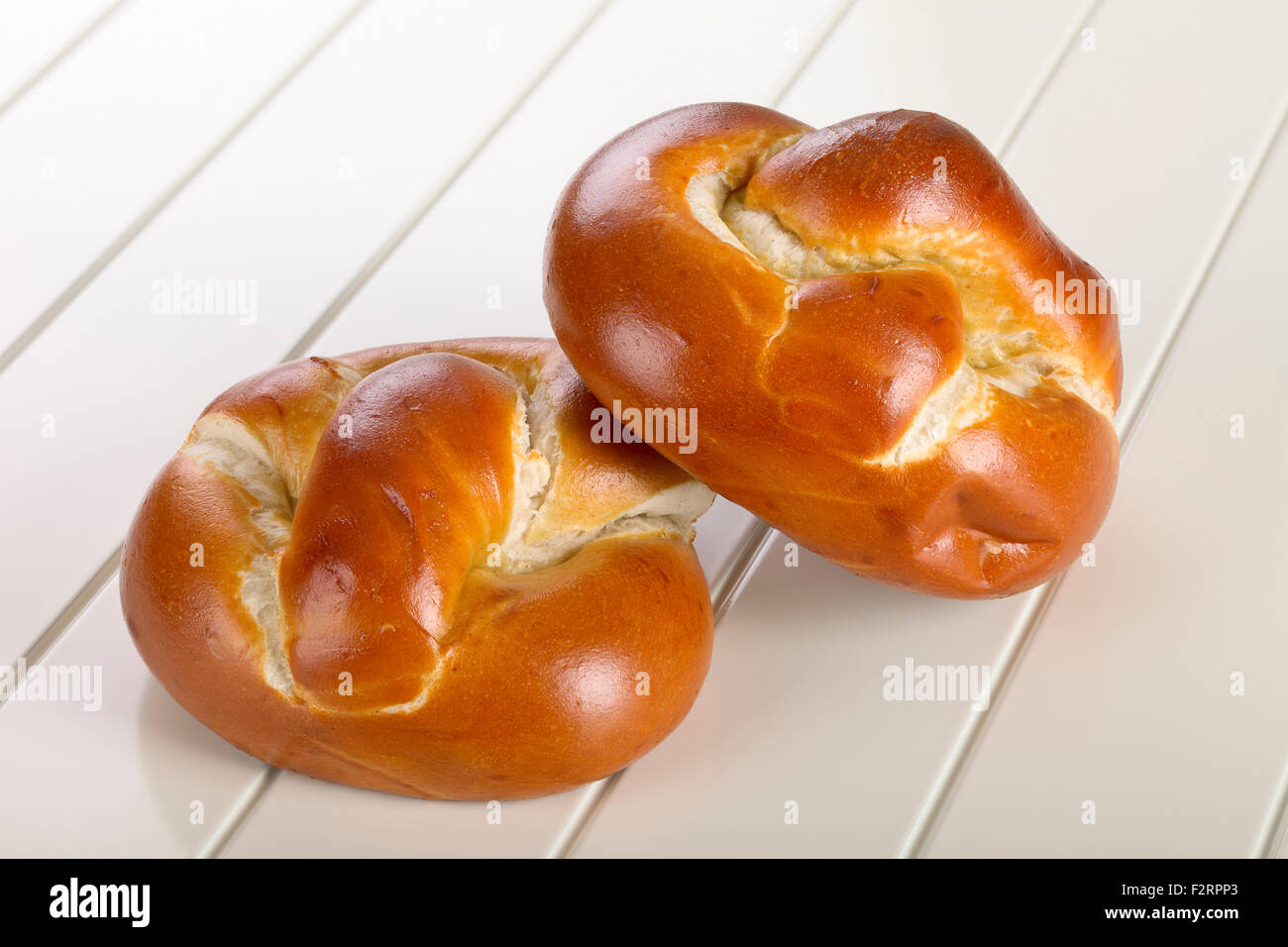 Bread roll on white wooden background. Stock Photo
