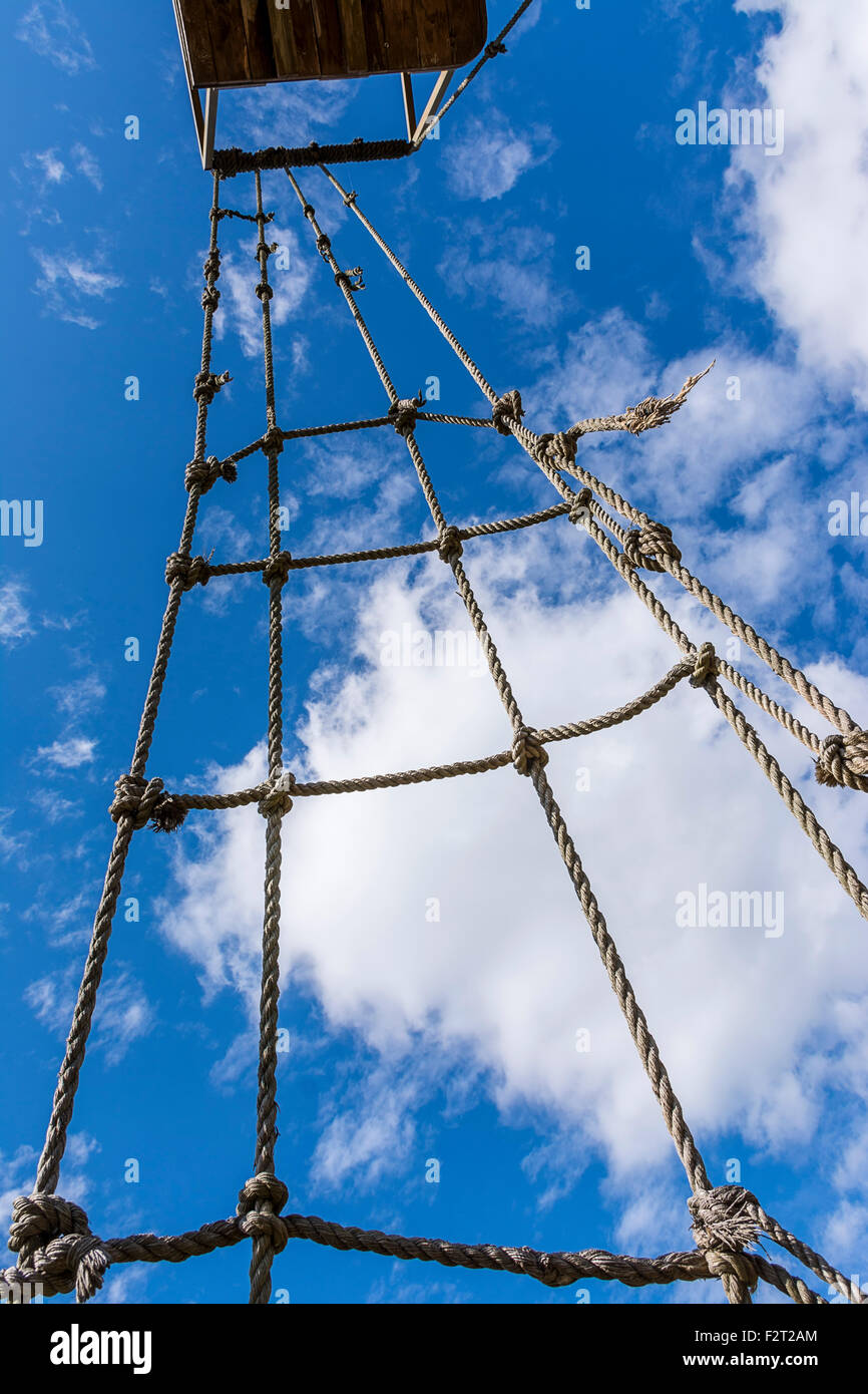 Old rope ladder against cloudy sky Stock Photo