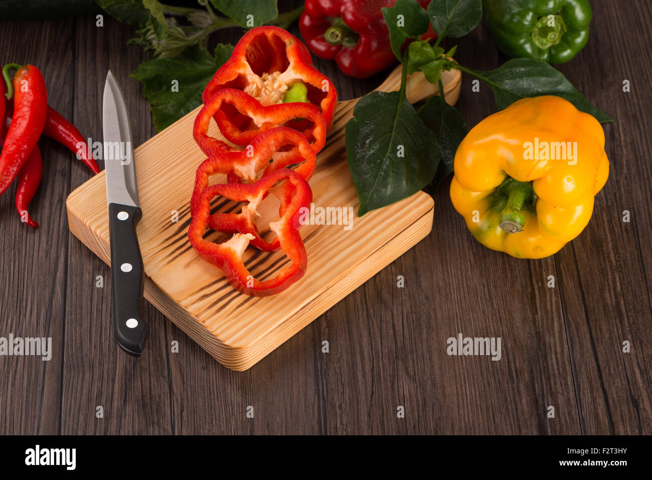 Colored bell peppers on old wooden table Stock Photo - Alamy