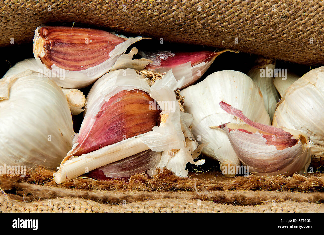 Whole garlic and cloves of garlic mixed in a sack Stock Photo