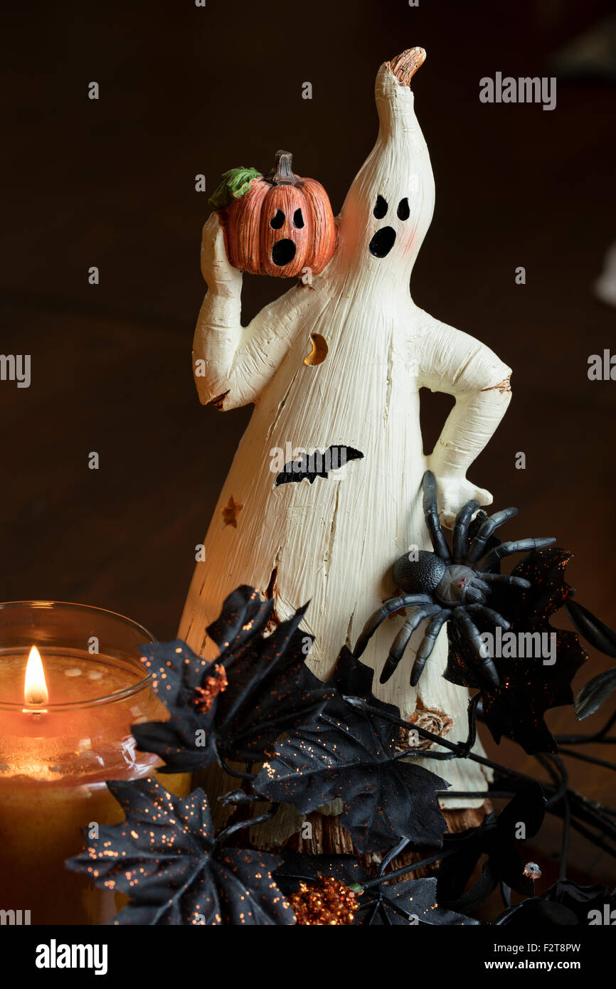 A ghost and pumpin sitting by a lit candle as a Halloween decoration Stock Photo