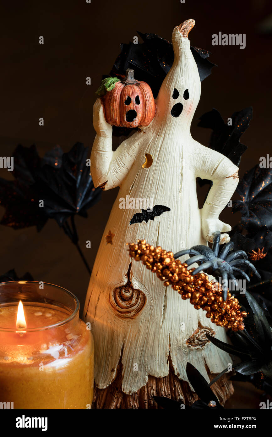 A ghost and pumpin sitting by a lit candle as a Halloween decoration Stock Photo