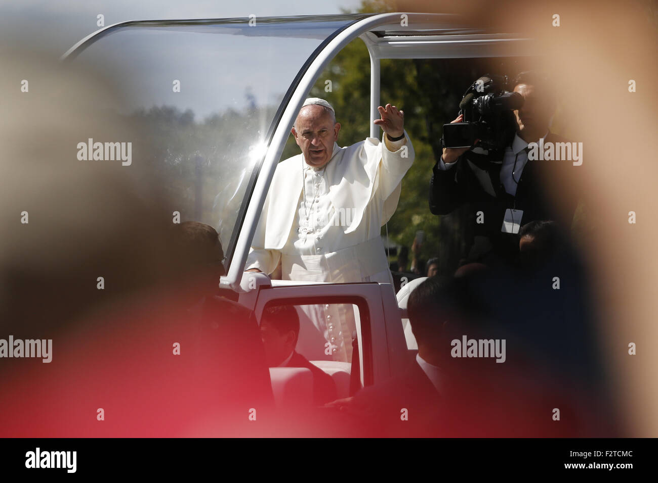 Washington, District of Columbia, USA. 23rd Sep, 2015. POPE FRANCIS waves from the popemobile during a parade as thousands of people gather at the National Mall. The Pope begins his first trip to the United States at the White House followed by a visit to St. Matthew's Cathedral, and will then hold a Mass on the grounds of the Basilica of the National Shrine of the Immaculate Conception. Credit:  Oliver Contreras/ZUMA Wire/Alamy Live News Stock Photo