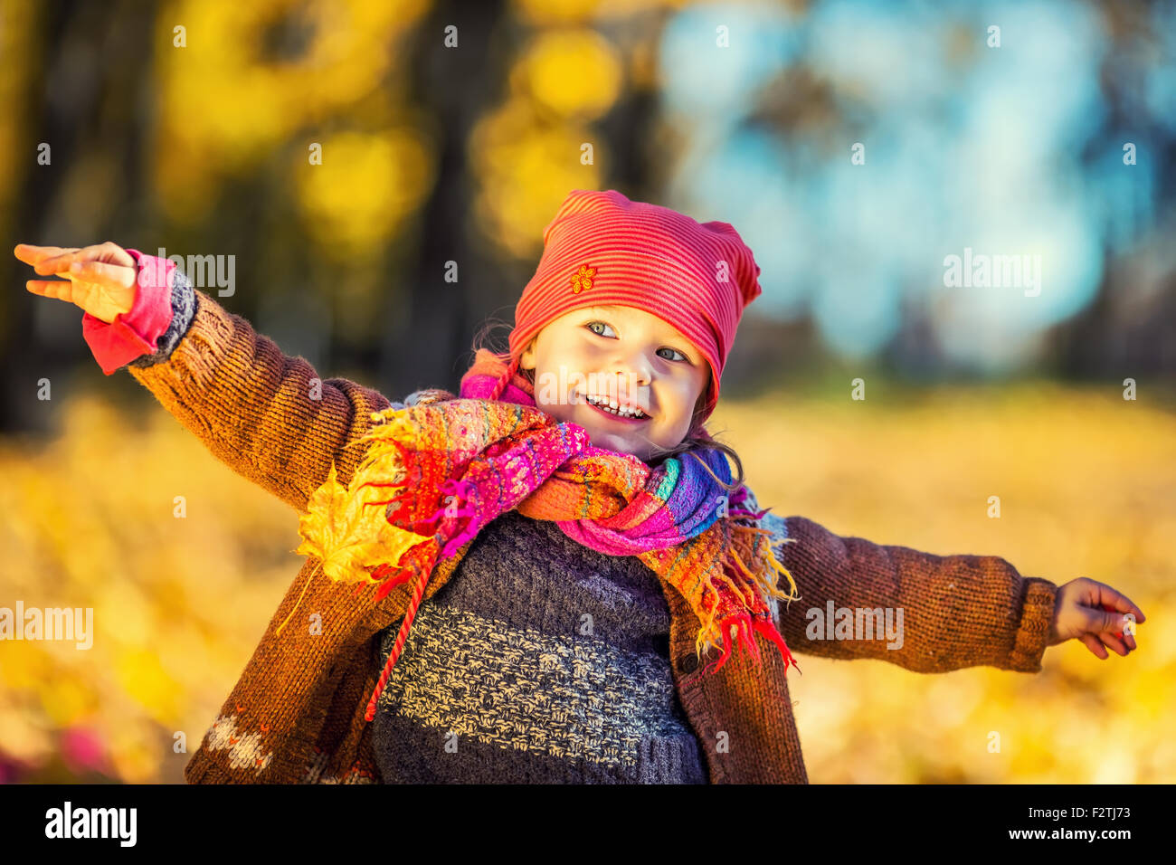 Happy little girl playing in the autumn park Stock Photo - Alamy