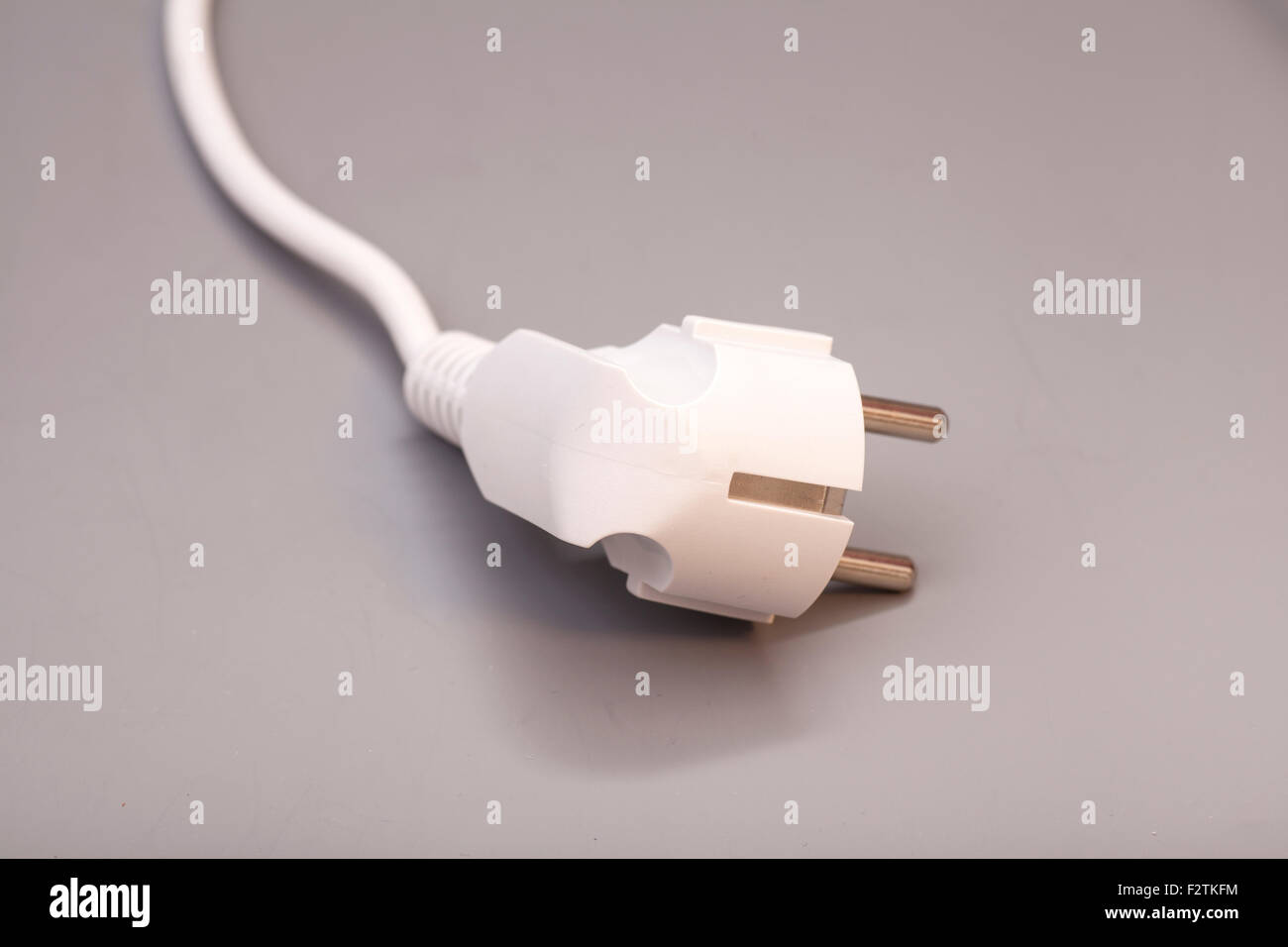 White plug isolated on gray background Stock Photo - Alamy