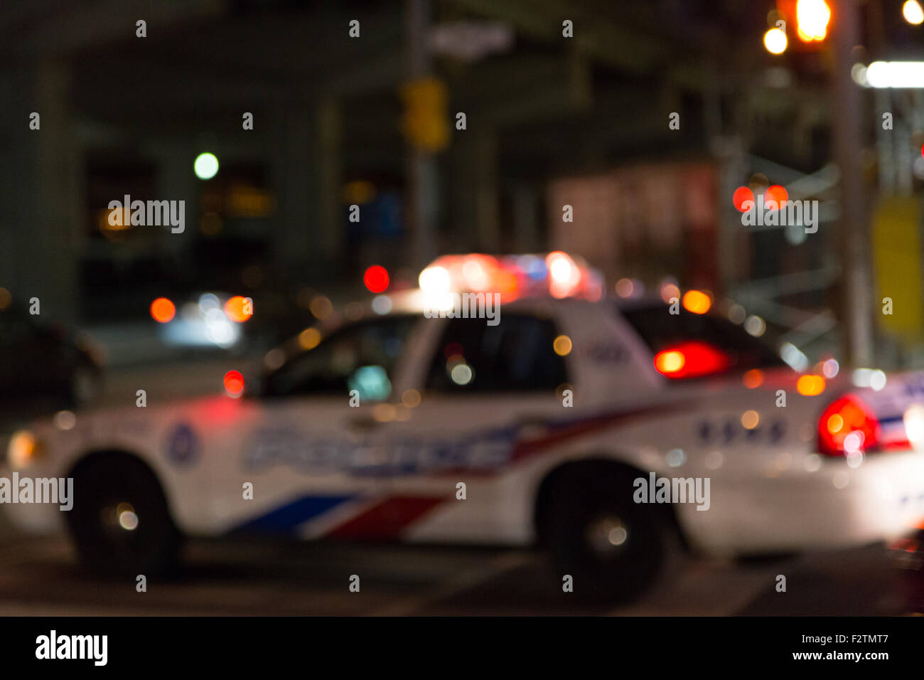 Defocussed Toronto Police Car parked on a street at night with it's lights on. Stock Photo