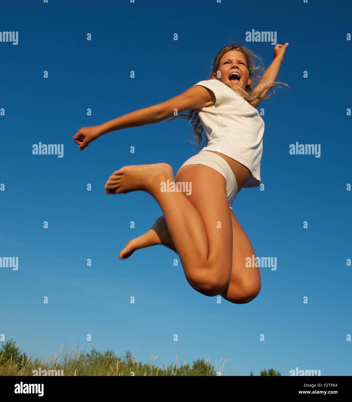 Happy little girl jumping Stock Photo - Alamy