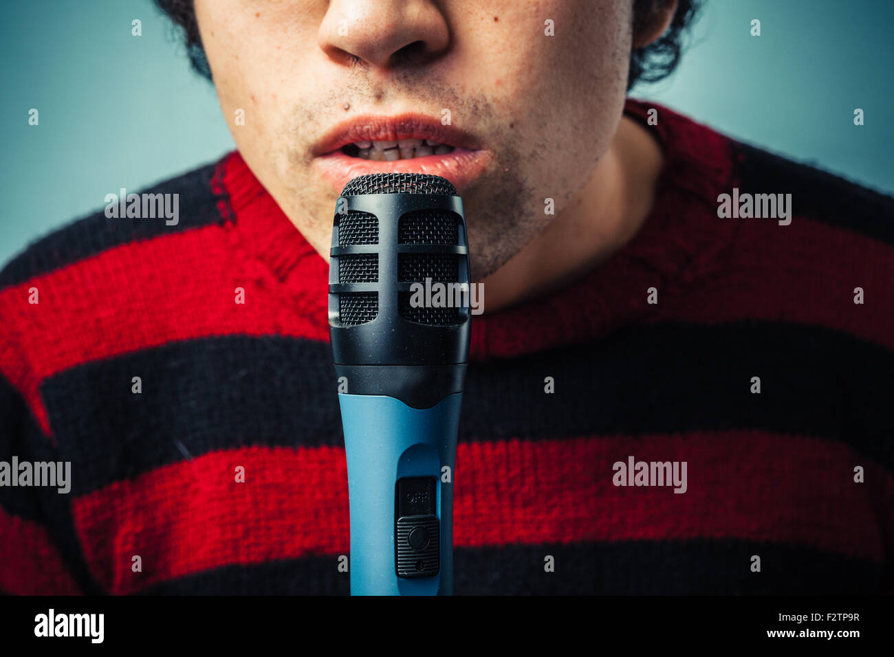 Close up on a young man speaking into a microphone Stock Photo