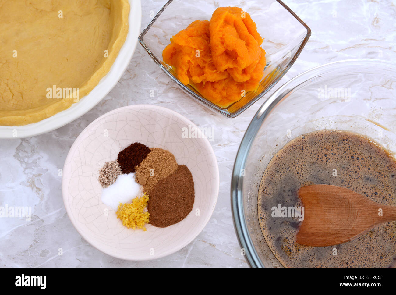 Making pumpkin pie - shortcrust pastry case, pumpkin puree, spices and egg and sugar mix Stock Photo