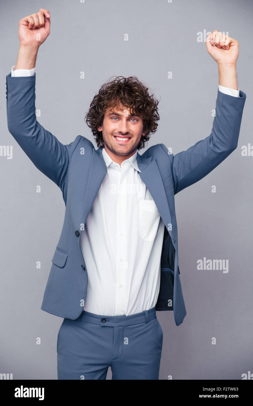 Portrait of a happy businessman celebrating his success with raised ...