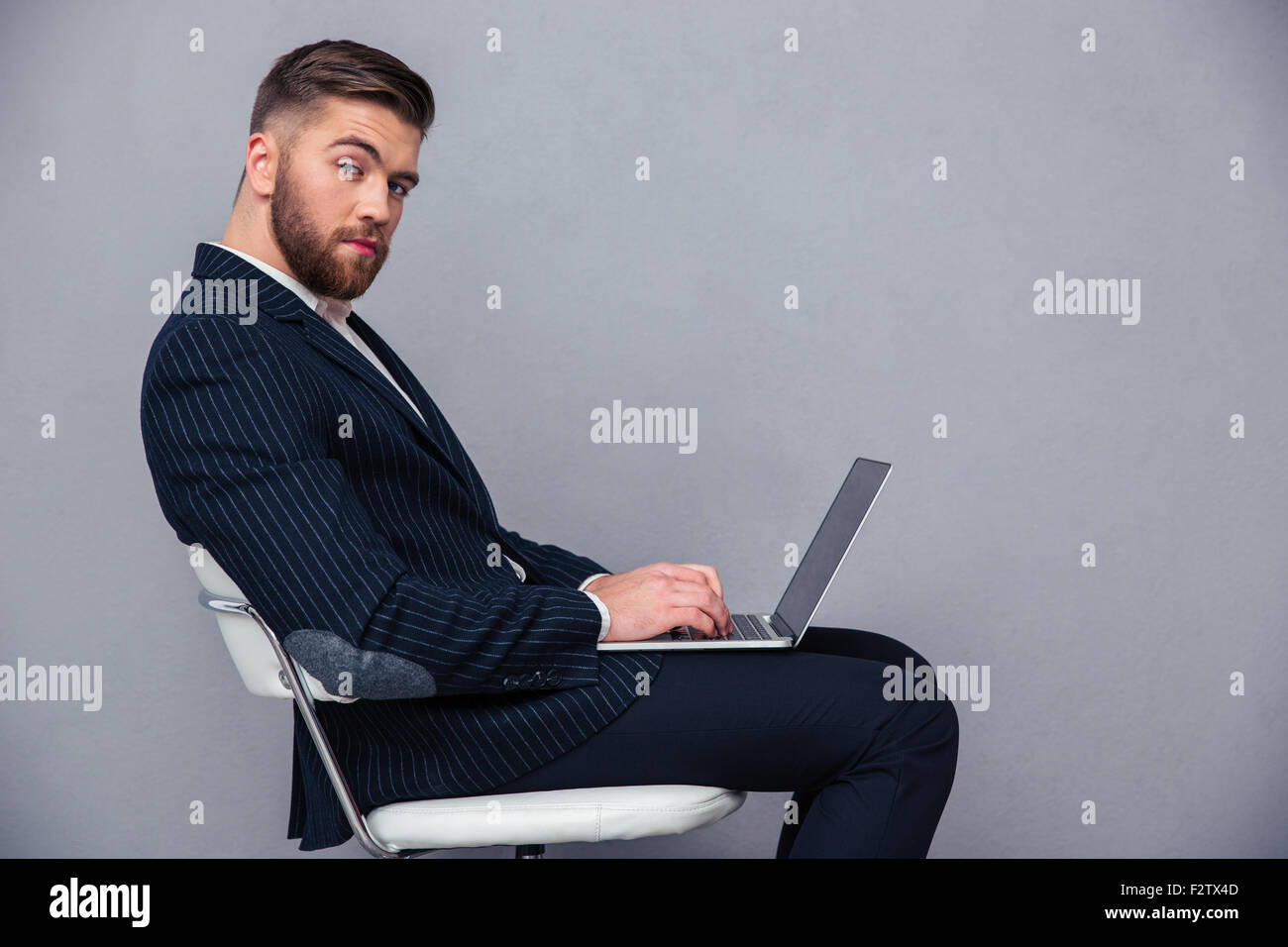 Portrait of a handsome businessman sitting on the office chair with ...