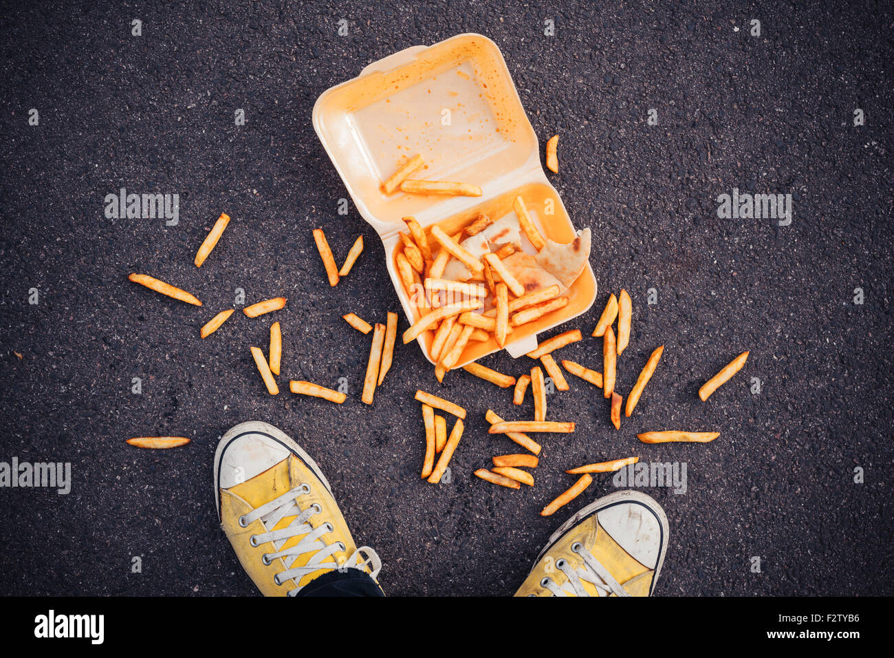 Young man has dropped his chips in the street Stock Photo