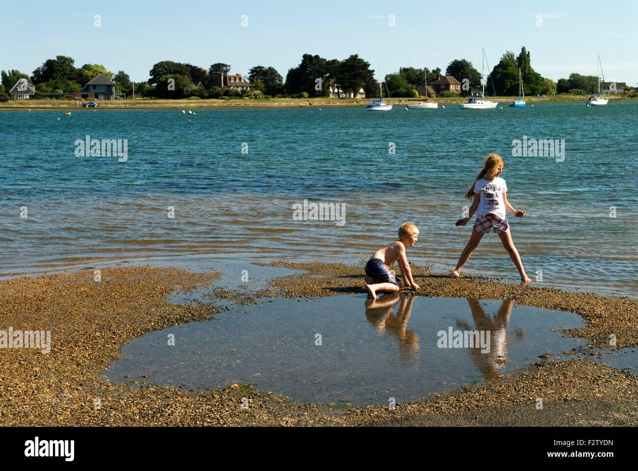 Bosham quay, kids brother sister playing together. England UK 2010s 2015 HOMER SYKES Stock Photo