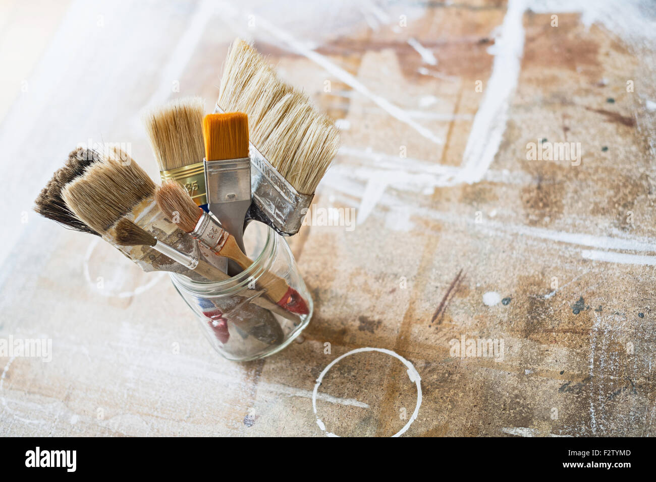 artist apron with paint brushes hanging on brick wall Stock Photo