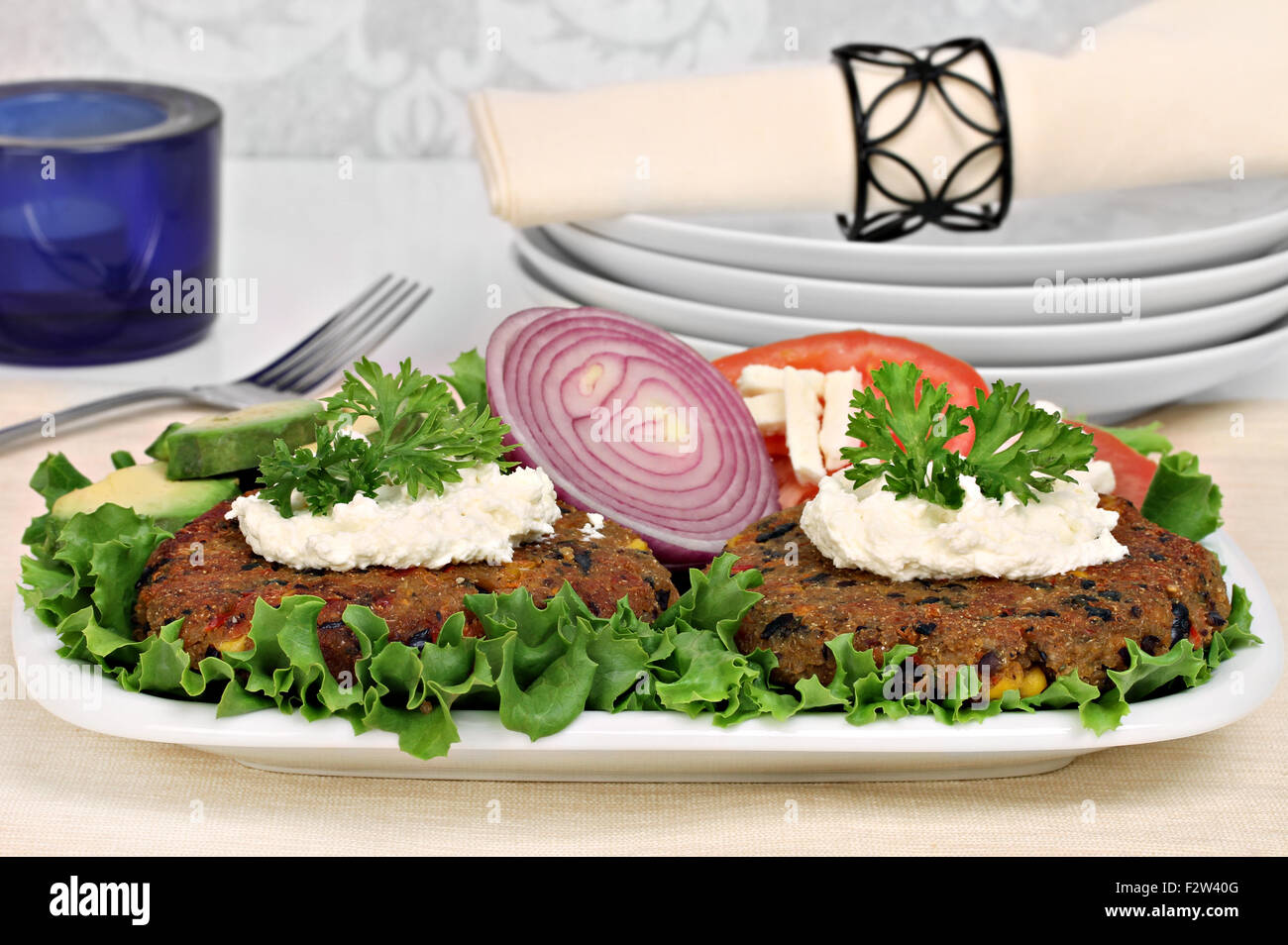 Two black bean vegetarian burgers topped with whipped goat cheese