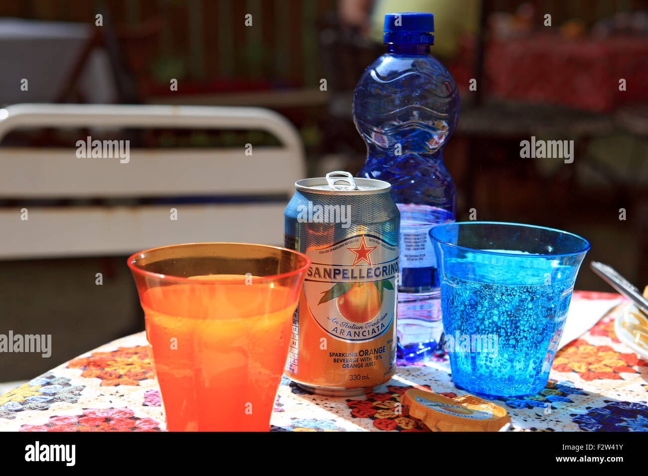 Drinks in bright coloured glasses on an outdoor table in a street cafe Stock Photo