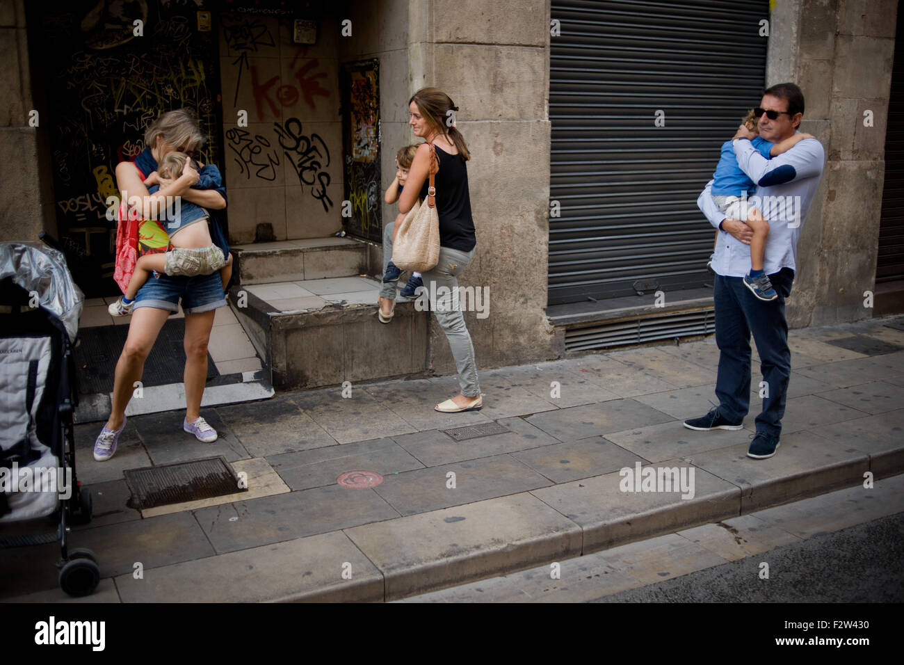 Barcelona, Catalonia, Spain. 24th Sep, 2015. Adults comfort to frightened children while Trabucaires shoot his blunderbusses through the streets of Barcelona on the occasion of the celebrations of the Merce Festival (Festes de la Merce) on 24 September 2015, Spain. The Galejada Trabucairemarks the beginning of the day of the patron saint of Barcelona, La Merce. Men and women dressed as ancient Catalan bandits take to the streets of the old part of Barcelona and cause a loud noise with his blunderbusses full of gunpowder. © Jordi Boixareu/ZUMA Wire/Alamy Live News Stock Photo