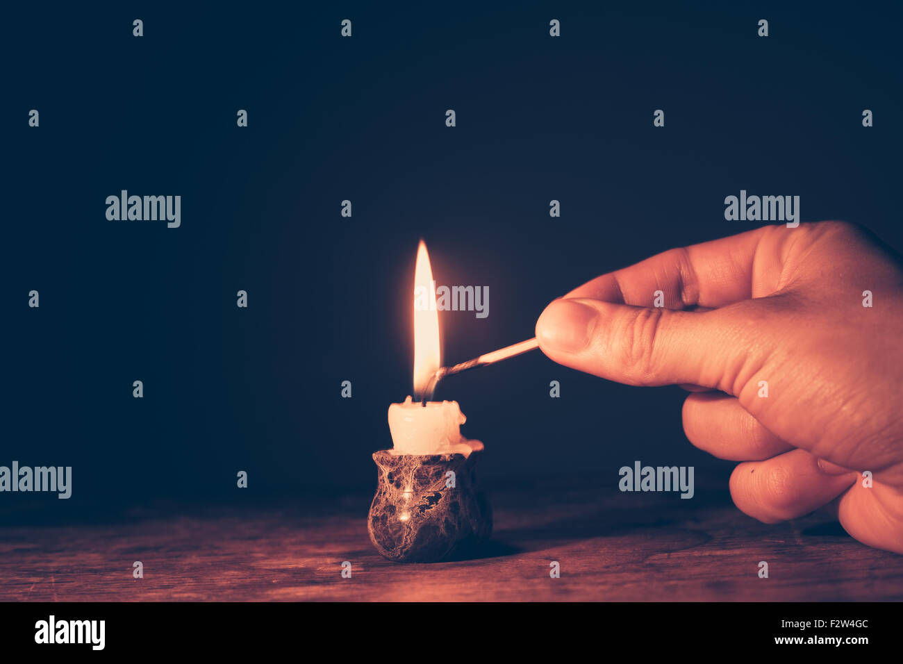 Man's hand is lighting a candle Stock Photo Alamy