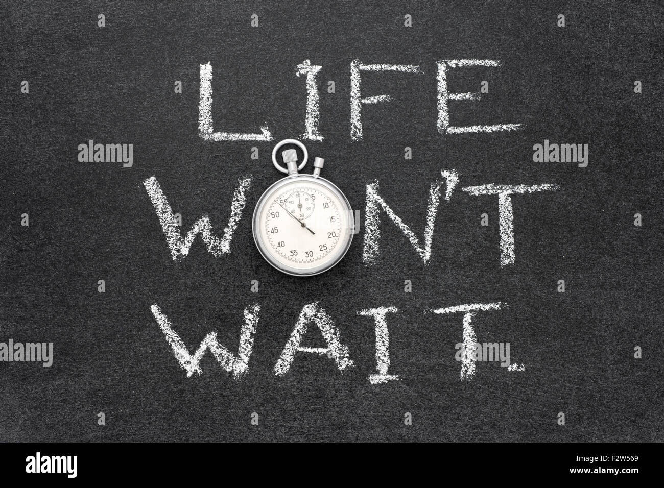 life wont wait phrase handwritten on chalkboard with vintage precise stopwatch used instead of O Stock Photo