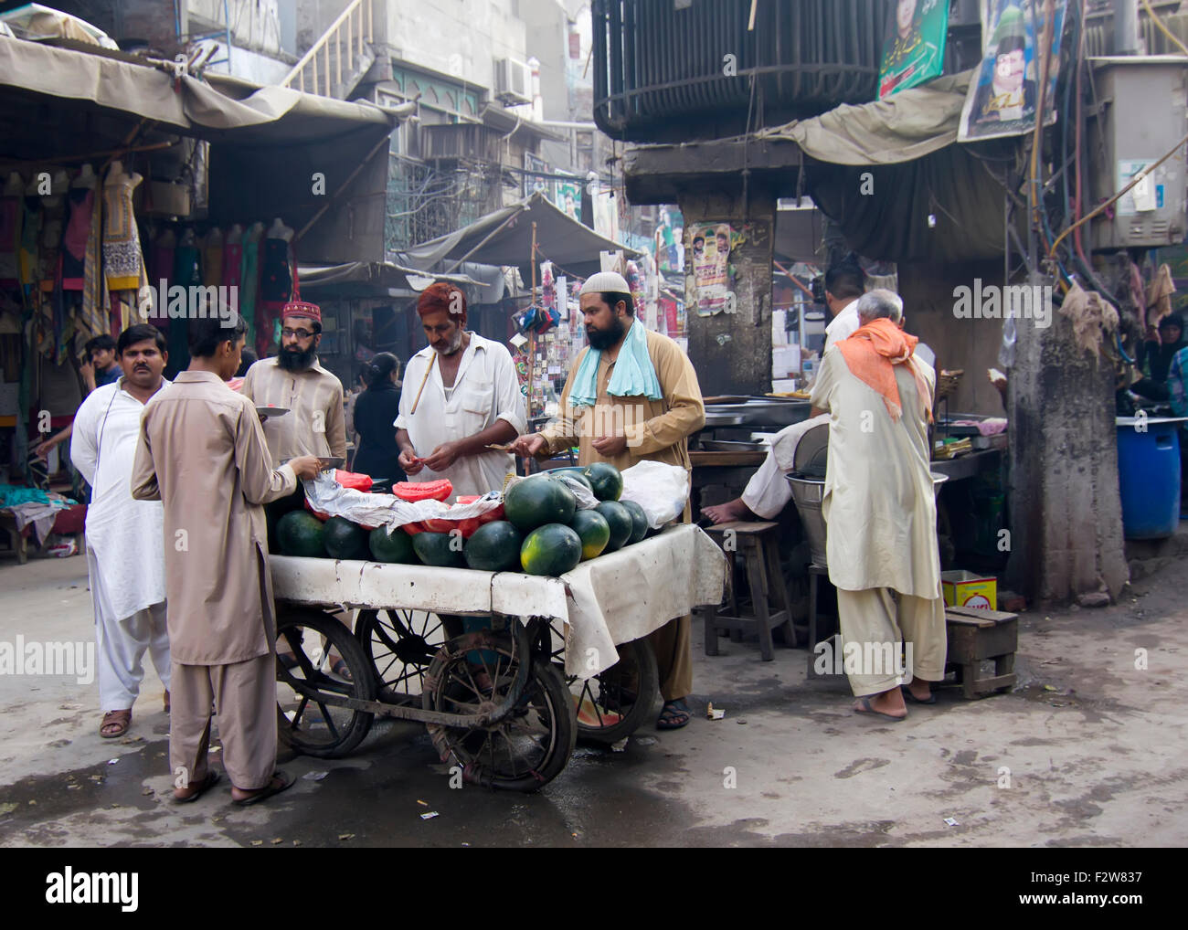 In 40°C degrees and no electricity passers-by stop for fresh watermelon at always busy and crowded Anarkali bazaar in Lahore, Pa Stock Photo